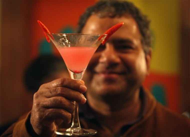 A man shows a cocktail he prepared at a how to party. Distillers, limited in how they can advertise, have sponsored some similar events.